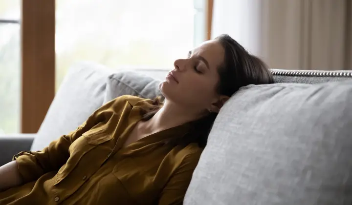 Frau erschöpft auf dem Sofa