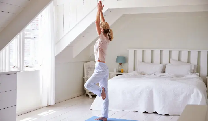 Frau beim Yoga im Schlafzimmer