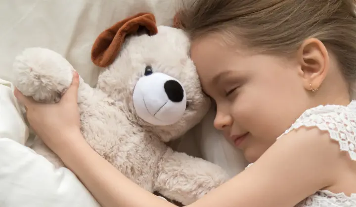 Mädchen mit Teddybär schläft